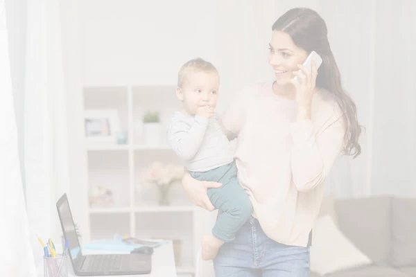 Woman holding baby while talking on a mobile phone.