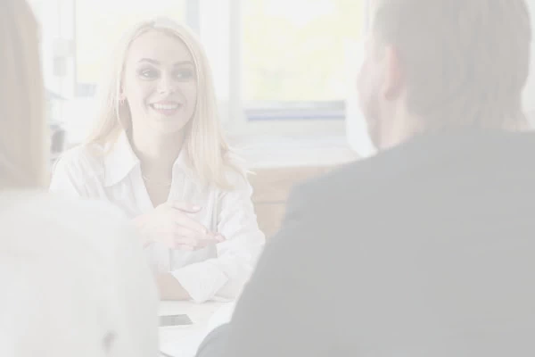 Woman behind a desk educating a young couple.