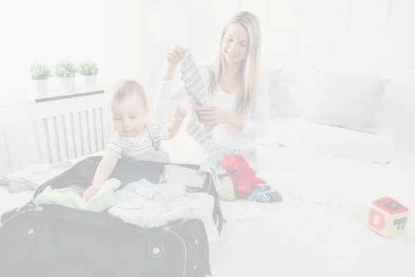 Woman and baby packing a suitcase.